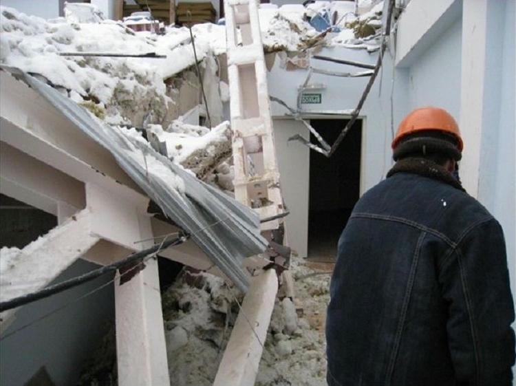 Специалист осматривает сломанную крышу